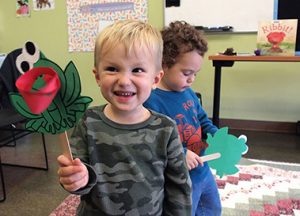 Two toddler boys with frog crafts at Little Paws Story Time